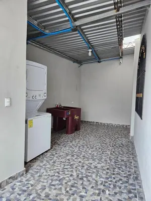 a room with a refrigerator and a table in it at La Casita Cruz in Caluco