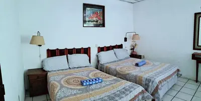 two beds in a room with two at casa de huéspedes lui in San Salvador