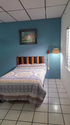 a bedroom with a bed in a blue wall at casa de huéspedes lui in San Salvador