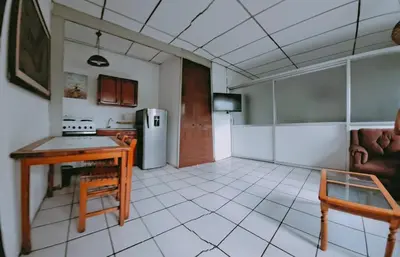 a kitchen with a table and a refrigerator at casa de huéspedes lui in San Salvador