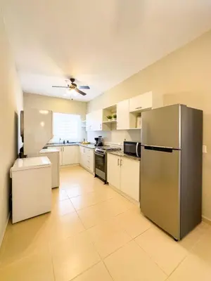 a large kitchen with white cabinets and a stainless steel refrigerator at Boa Mare in Nanastepeque