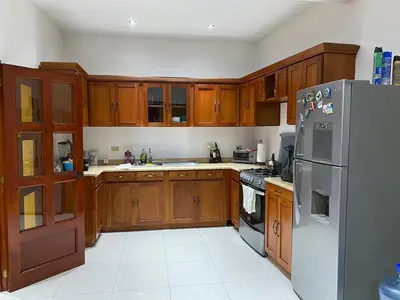 a kitchen with wooden cabinets and a stainless steel refrigerator at Modern colonial house