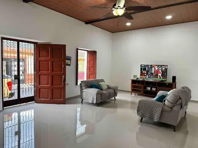a living room with two chairs and a tv at Modern colonial house