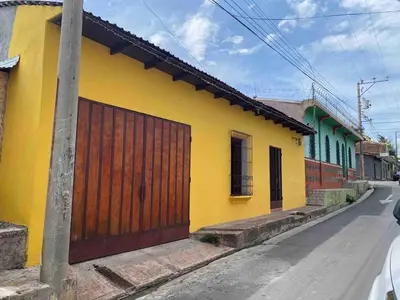 a yellow building with a wooden door on a street at Modern colonial house