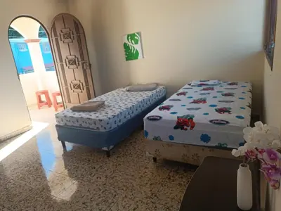 a bedroom with two twin beds and a doorway at habitación doble amueblada baño privado in San Salvador