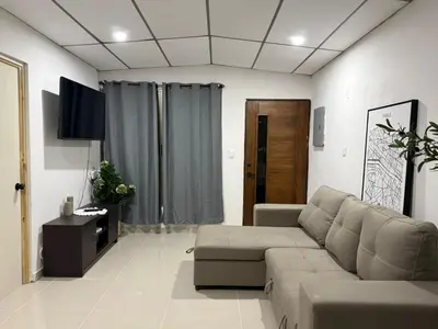 a living room with a couch and a table at Ciudad Merliot, casa Don Pablo in Hacienda Plan de La Laguna