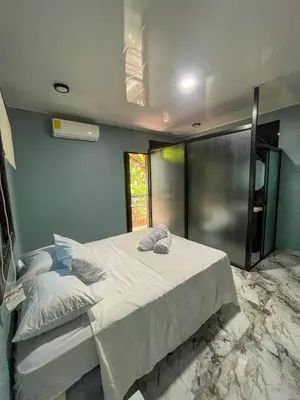 a bedroom with a large white bed with a window at El Mangal del Zonte in El Zonte