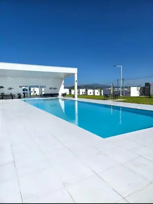 a blue swimming pool with a white pavilion at Candy House Marsella in Sitio Grande