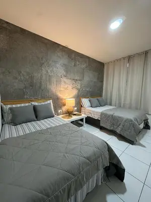 a bedroom with two beds and a table with a lamp at Apartment D Fuertevali in San Salvador