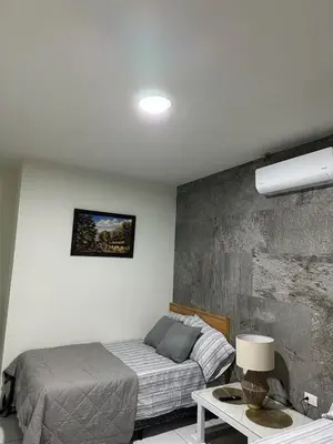 a bedroom with a bed and a table with a lamp at Apartment D Fuertevali in San Salvador