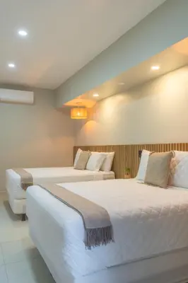 two beds in a hotel room with two beds at Miradora House in El Sunzal