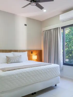 a bedroom with a white bed and a window at Miradora House in El Sunzal
