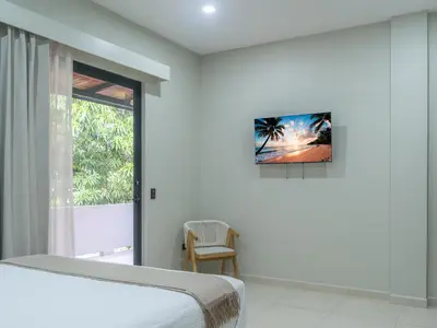 a white bedroom with a bed and a window at Miradora House in El Sunzal