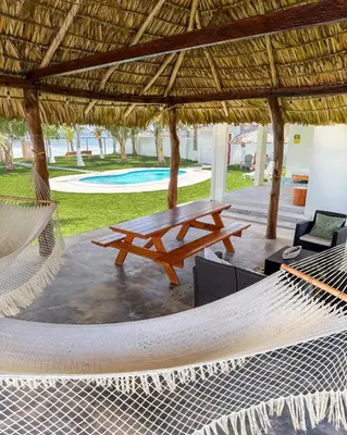 a hammock and a picnic table in a pavilion at Azul Beach House in La Esmeralda