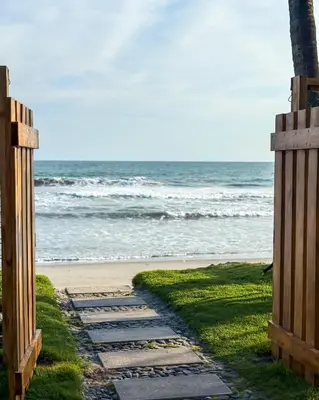 a pathway leading to the beach with the ocean in the background at Azul Beach House in La Esmeralda
