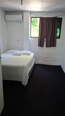 a small room with a bed and a window at Hostel Bella Luna in El Zonte