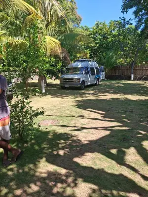 a person walking past a van parked in a yard at Hostel Bella Luna in El Zonte