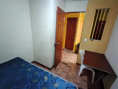 a room with a bed and a table and a door at Rooms libertad in San Salvador