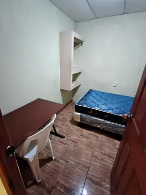 a room with a bed and a chair in it at Rooms libertad in San Salvador