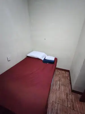 a bed in a small room with a red mattress at Rooms libertad in San Salvador
