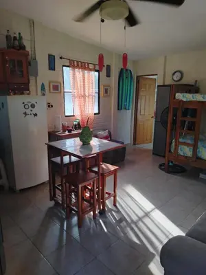 a kitchen and living room with a table and a refrigerator at La Casita de la Playa La Bocana San Juan in Metalío