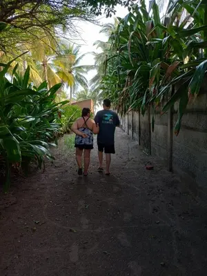 a man and a woman walking down a path at La Casita de la Playa La Bocana San Juan in Metalío