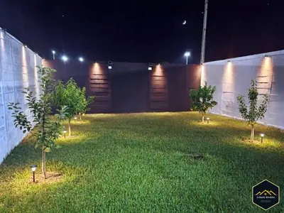 a backyard at night with trees in the grass at Casa Brisa Volcanica - Residencial Nueva San Miguel with AC in San Miguel