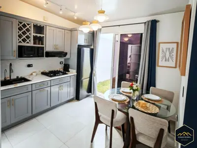 a kitchen with a table with chairs and a dining room at Casa Brisa Volcanica - Residencial Nueva San Miguel with AC in San Miguel