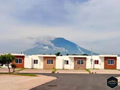 a row of houses with a mountain in the background at Casa Brisa Volcanica - Residencial Nueva San Miguel with AC in San Miguel