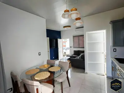 a dining room and living room with a table and chairs at Casa Brisa Volcanica - Residencial Nueva San Miguel with AC in San Miguel