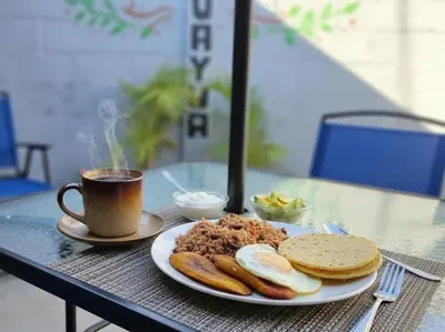 a plate of food and a cup of coffee on a table at Casa Juanita Juayua in Juayúa