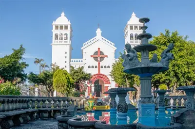 a large white building with two towers and a fountain at Casa Juanita Juayua in Juayúa