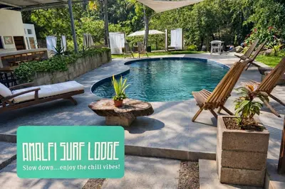 a swimming pool in a backyard with a patio furniture at Amalfi Surf Lodge in ChiltiupÃ¡n