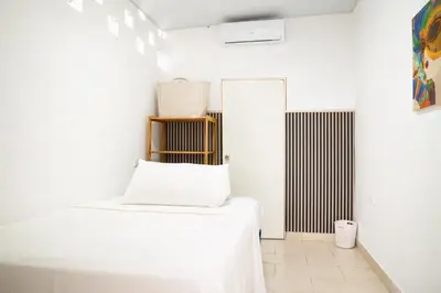a white room with a bed and a mirror at Amalfi Surf Lodge in ChiltiupÃ¡n