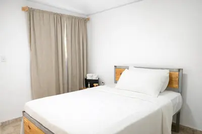 a bedroom with a white bed and a window at Amalfi Surf Lodge in ChiltiupÃ¡n