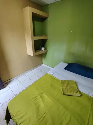 a bed in a room with a green wall at Rooms libertad in San Salvador