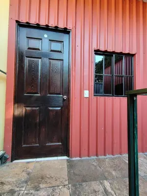 a brown door and a window on a red wall at Rooms libertad in San Salvador