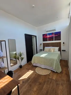 a bedroom with a bed with a green bedspread at Apartamento nuevo a 90m del Magico con 2 parqueos incluidos in San Salvador