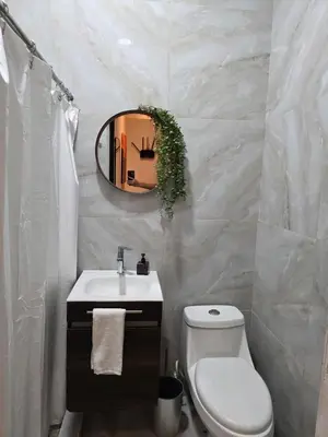 a bathroom with a sink and a toilet and a mirror at Apartamento nuevo a 90m del Magico con 2 parqueos incluidos in San Salvador