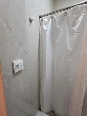 a shower with a white shower curtain in a bathroom at Apartamento nuevo a 90m del Magico con 2 parqueos incluidos in San Salvador