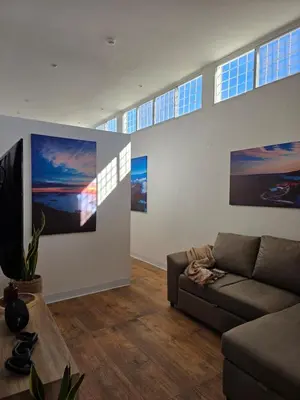 a living room with a couch and paintings on the wall at Apartamento nuevo a 90m del Magico con 2 parqueos incluidos in San Salvador