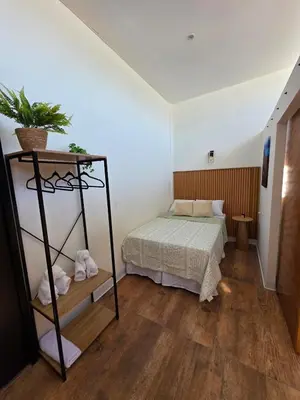 a bedroom with a bed and a plant on a shelf at Apartamento nuevo a 90m del Magico con 2 parqueos incluidos in San Salvador