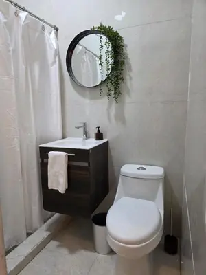 a bathroom with a toilet and a sink and a mirror at Apartamento nuevo a 90m del Magico con 2 parqueos incluidos in San Salvador