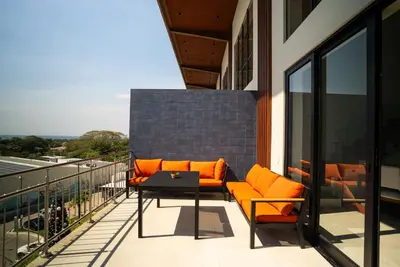 a balcony with orange chairs and a table on a building at Oceanview Greco Loft in Playa San Blas