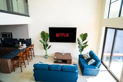 a living room with a blue couch and a tv at Oceanview Greco Loft in Playa San Blas