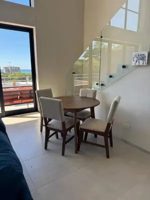 a dining room with a wooden table and chairs at Oceanview Greco Loft in Playa San Blas