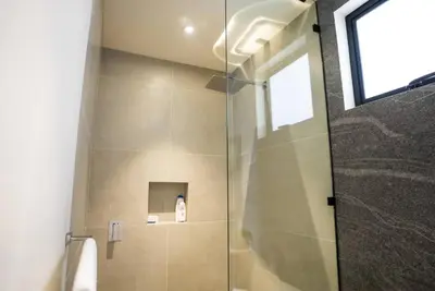a shower with a glass door in a bathroom at Oceanview Greco Loft in Playa San Blas