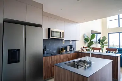a kitchen with a stainless steel refrigerator and a sink at Oceanview Greco Loft in Playa San Blas
