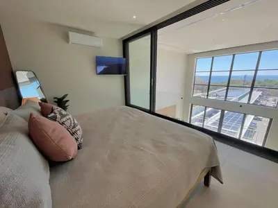 a bedroom with a bed and a large window at Oceanview Loft Mare in Playa San Blas