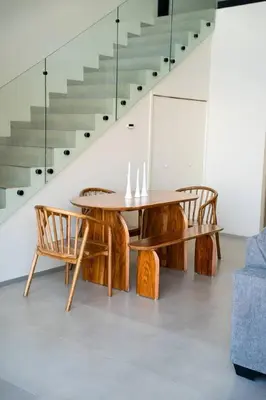 a wooden table and chairs in a room with stairs at Oceanview Loft Mare in Playa San Blas